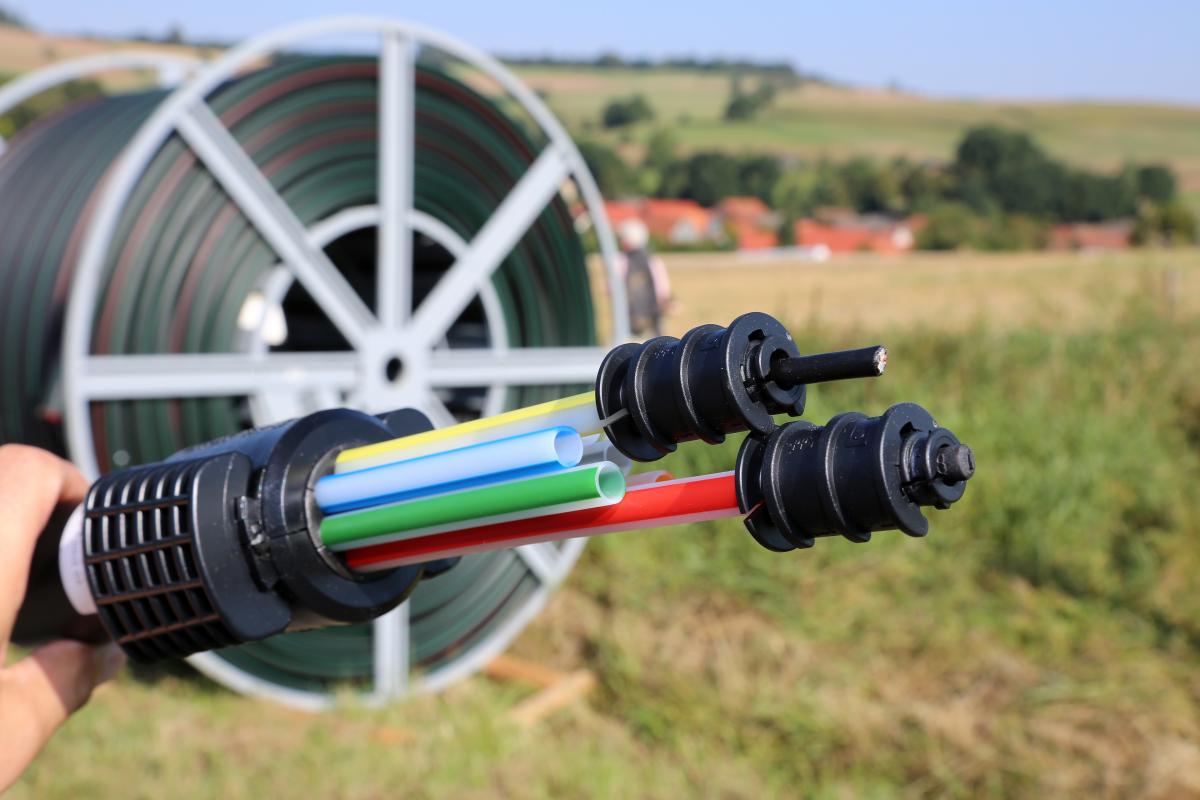 Breitband Glasfaserkabel, im Hintergrund ländliche Landschaft