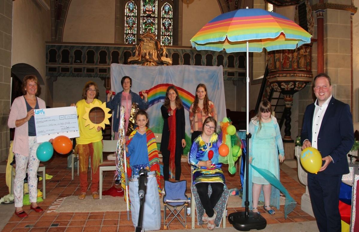 Kinder und Erwachsene stehen in einer Kirche vor dem Altar.