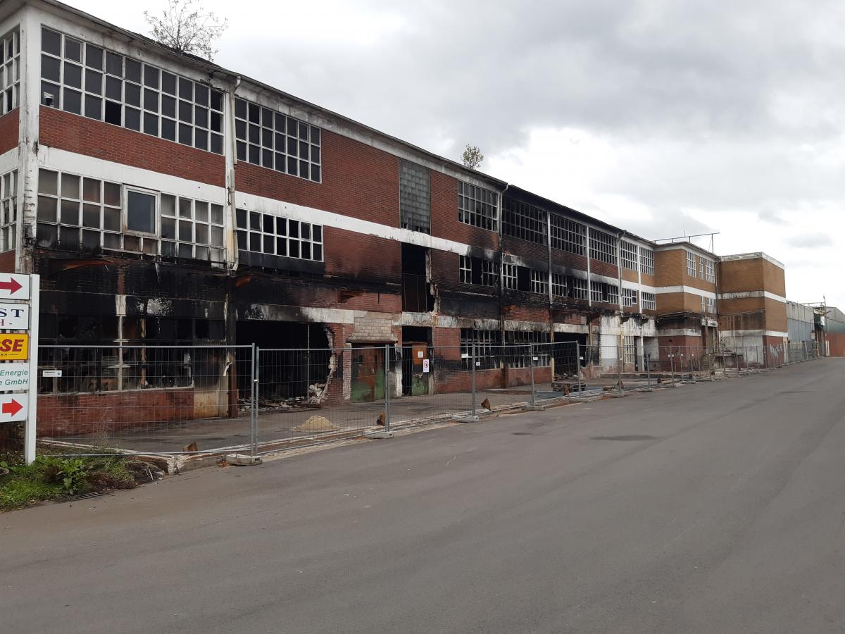 Die zerstörte Werkshalle mit den unterschiedlichen Abfallfraktionen. Fabrik, abgebrannt