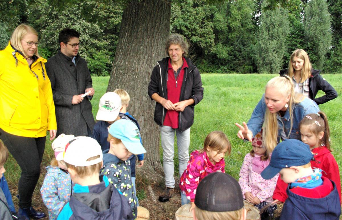 Kinder und Erwachsene unter einem Baum