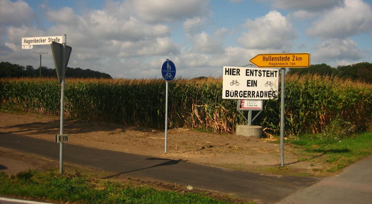 Bürgerradweg Radweg mit Verkehrsschildern vor einem Maisfeld