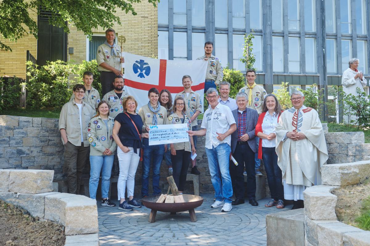 Personengruppe mit Flagge vor Haus