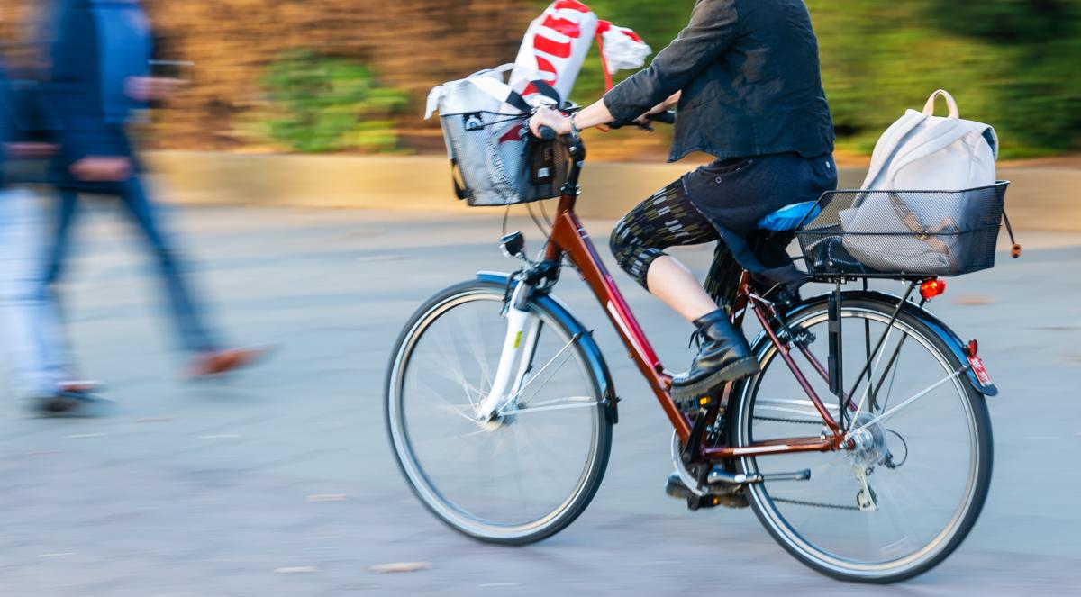 Person mit Fahrrad auf Radweg. Andere Person kommt zu Fuß entgegen.