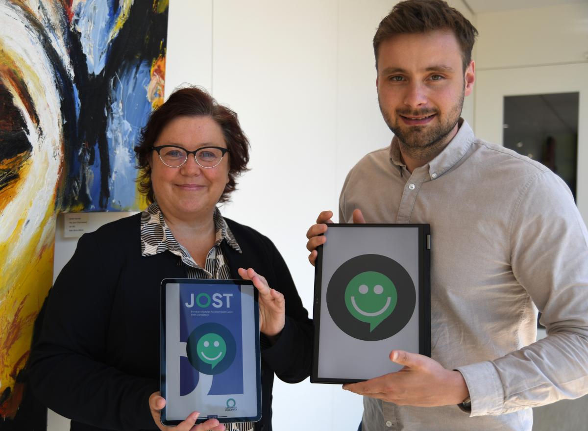 Zwei Personen halten Tablets in die Kamera.