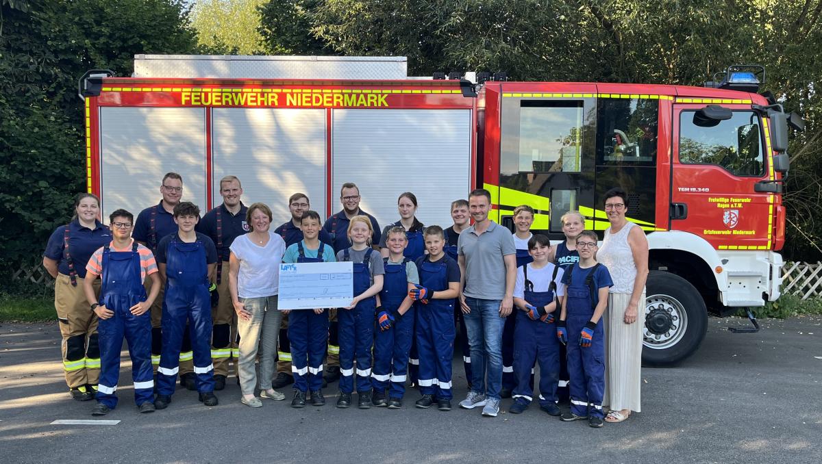 Jugendfeuerwehr Hagen Eine Personengruppe steht vor einem Feuerwehrfahrzeug.