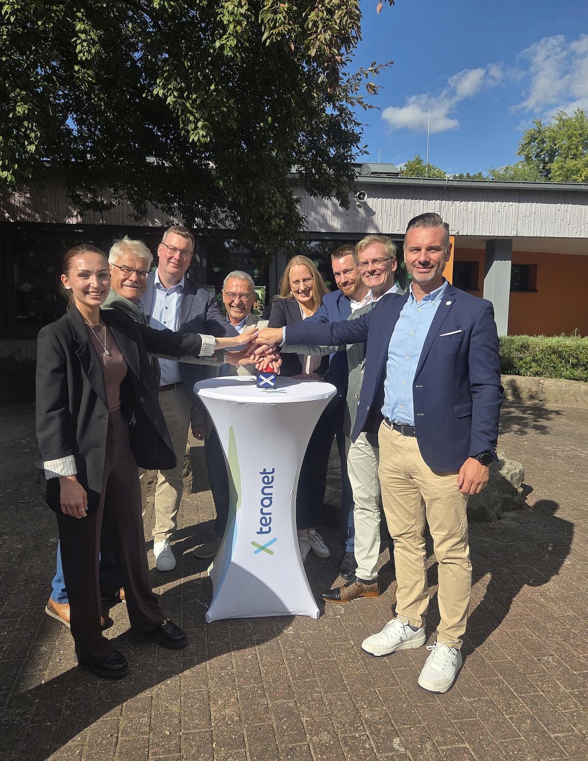 Gruppe von Personen um Stehtisch