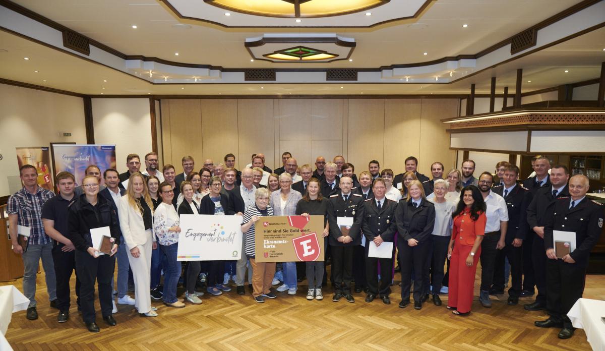 Personengruppe steht in einem Saal