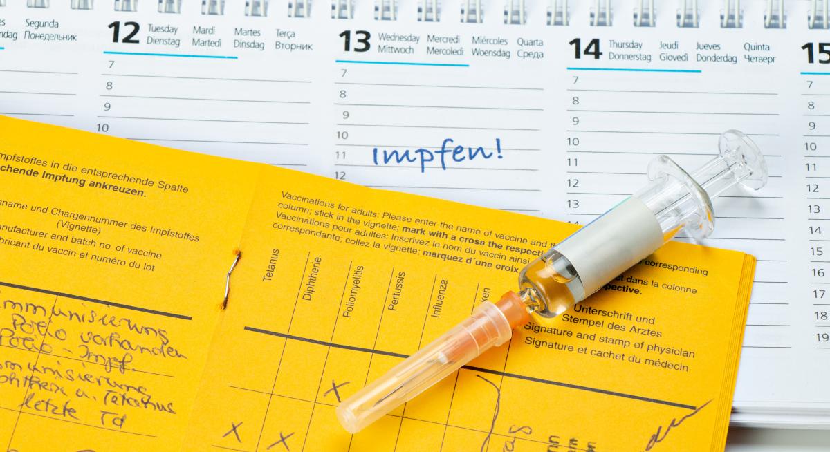 Impfungen, Reiseimpfungen Impfausweis und eine Spritze