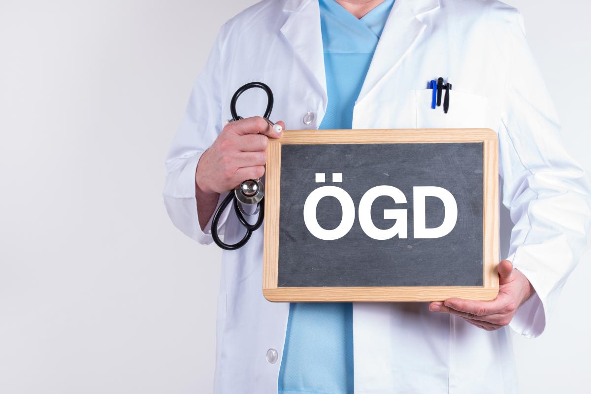 ÖGD Person hält Schiefertafel mit der Aufschrift ÖGD.