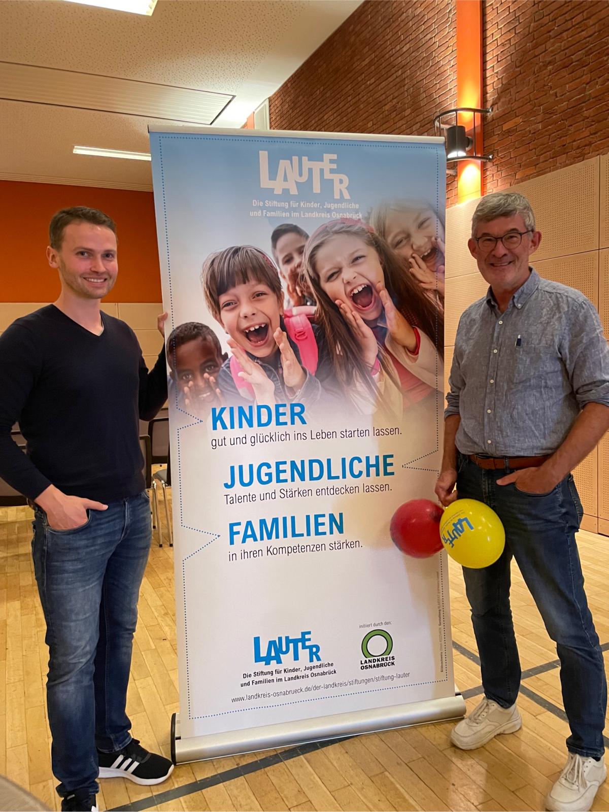 2 Personen vor Plakat