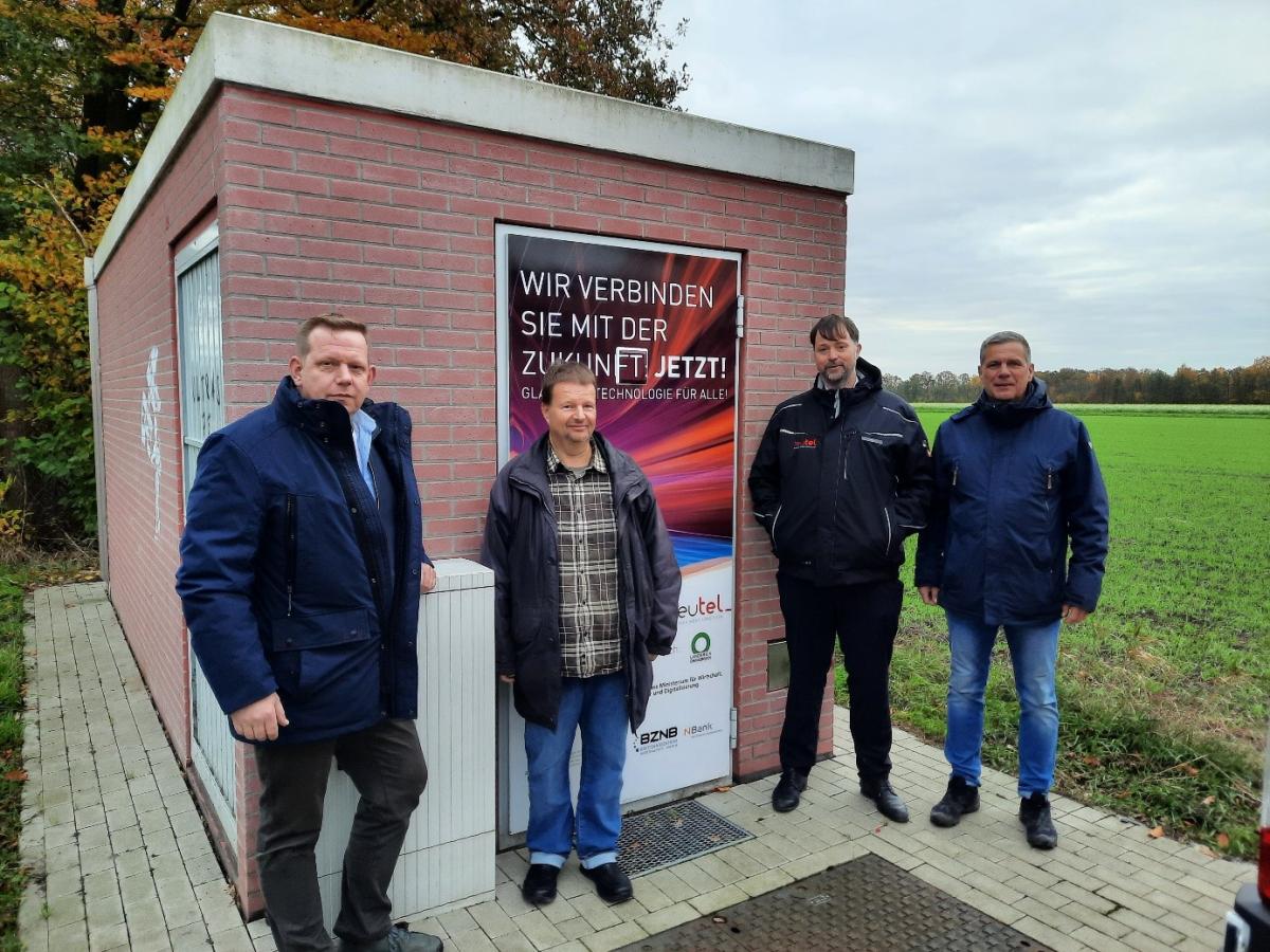 Vier Personen stehen vor einem technischen Gebäude.