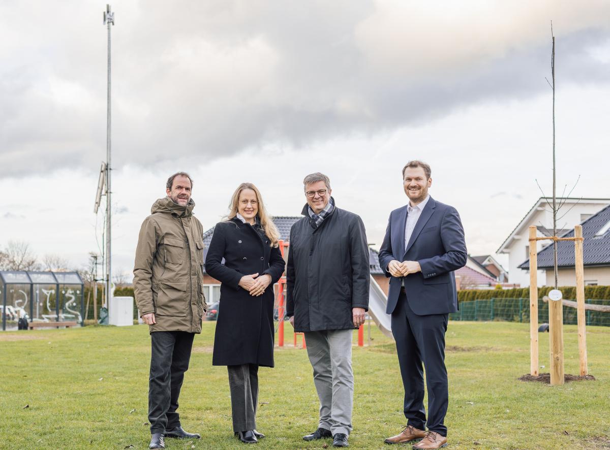 Vier Personen stehen vor einer Sirene.