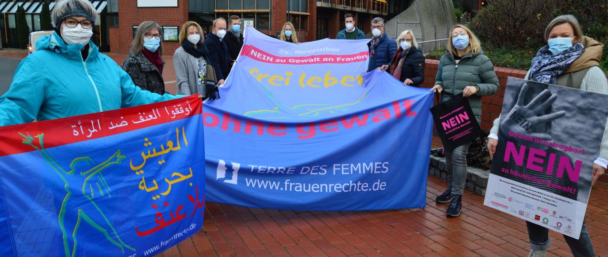 Gruppensituation vor dem Kreishaus mit Fahne von TERRE DES FEMMES