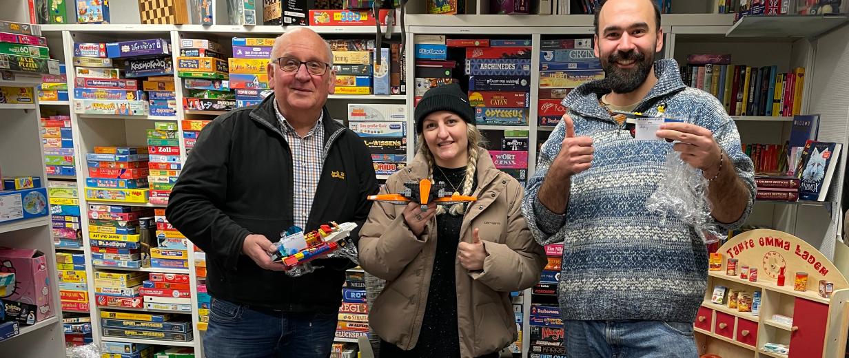 3 Personen vor Lego-Tüten stehend