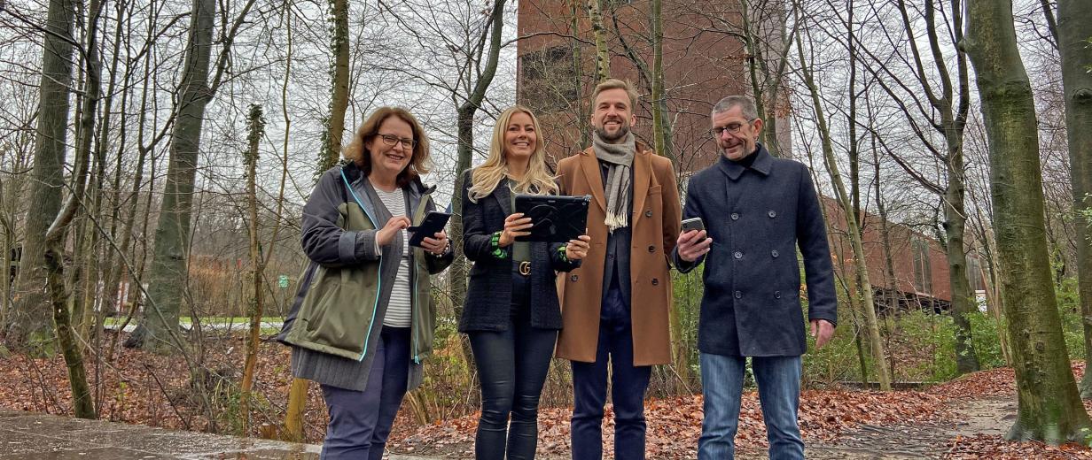 4 Personen im Freien mit Handy