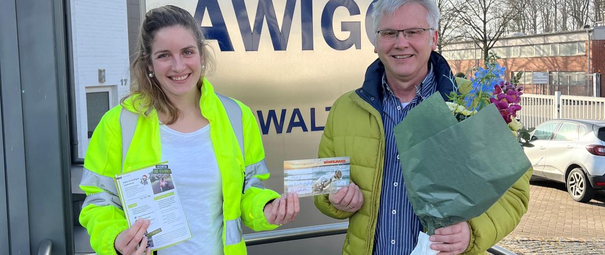 AWIGO Gewinnspiel Zwei Personen stehen vor dem Eingang eines Firmengebäudes.