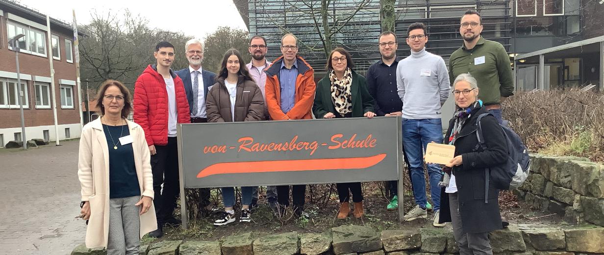 Gruppe von Personen vor Schule