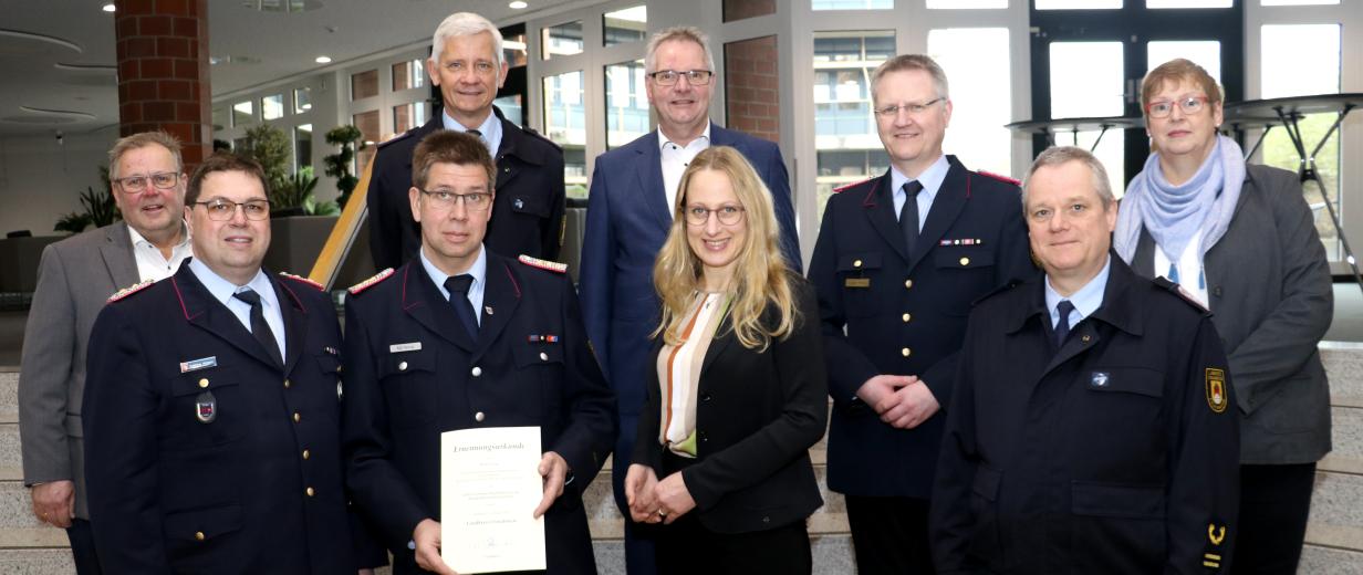 Gruppe von Feuerwehrleute (und Landrätin Kebschull) in einem Foyer