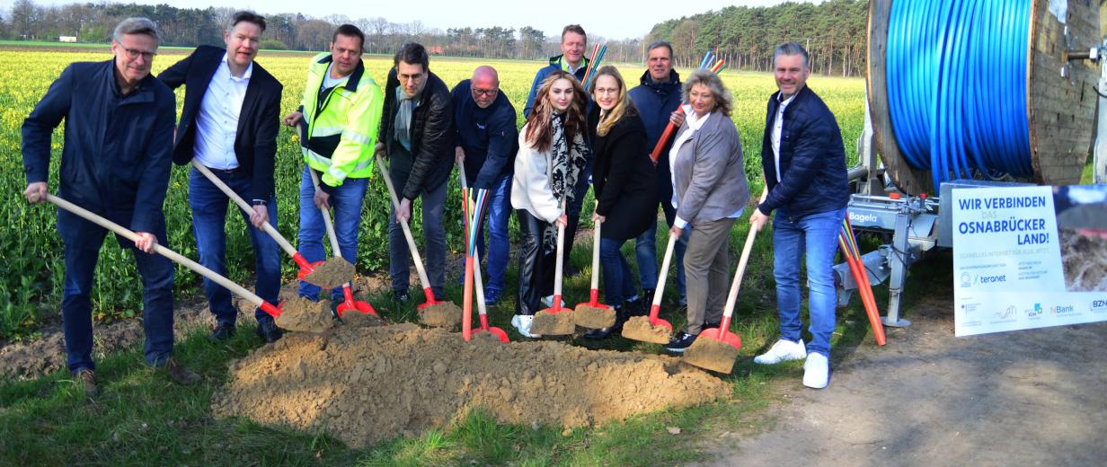 Breitbandausbau Bramsche Wallenhorst Eine Personengruppe steht am Rande eines Feldes und hat Schaufeln in der Hand.
