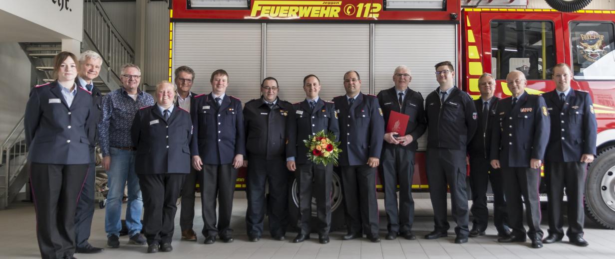 Kreisjugendfeuerwehrtag 2023 Eine Personengruppe in dunkelblauen Uniformen steht vor einem Feuerwehrfahrzeug.