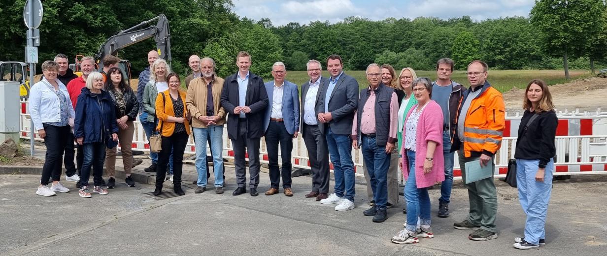 K305 Bauarbeiten in Hasbergen Eine Personengruppe steht vor der Absperrung einer Straßenbaustelle