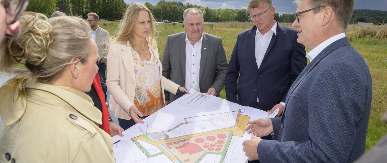 Neuer Pächter für Gewerbefläche am Hafen Wittlager Land Gruppe von Personen mit Kartenmaterial im Freien