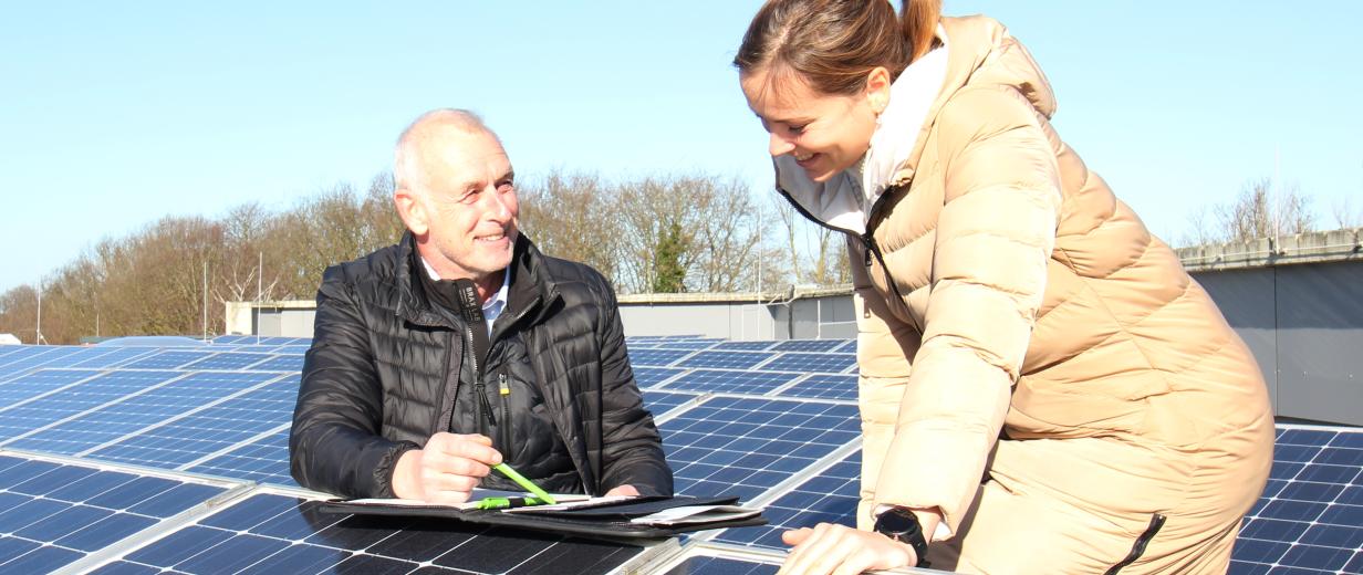 Zwei Personen zwischen Solaranlagen