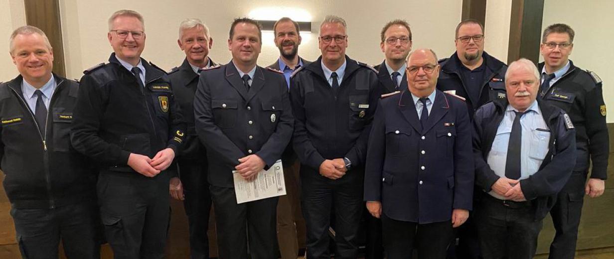 Kreisfeuerwehr Dienstbesprechung Ehrung Kreisausbilder Personengruppe in blauen Uniformen steht in einem Raum.