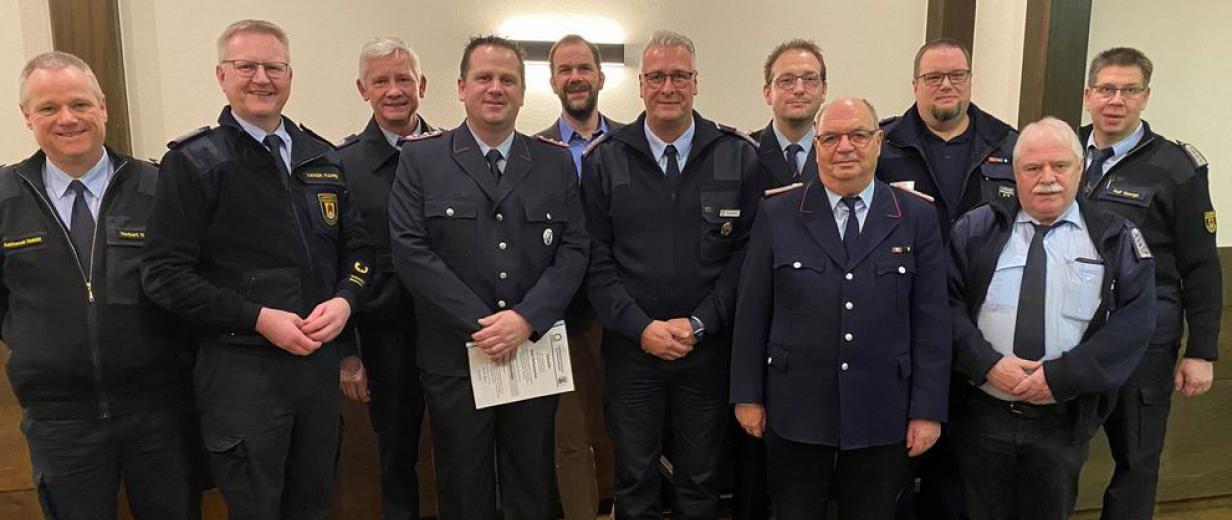 Personengruppe in blauen Uniformen steht in einem Raum.