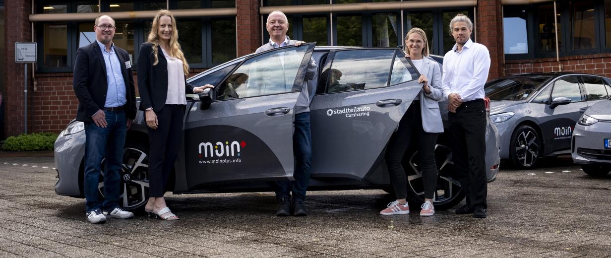 Carsharing-Angebot im Landkreis Osnabrück wird erweitert 5 personen um ein Auto stehend