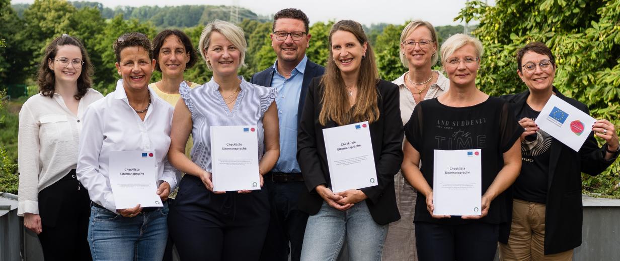 Checkliste Elternansprache MaßArbeit Eine Personengruppe steht auf einer Terrasse.