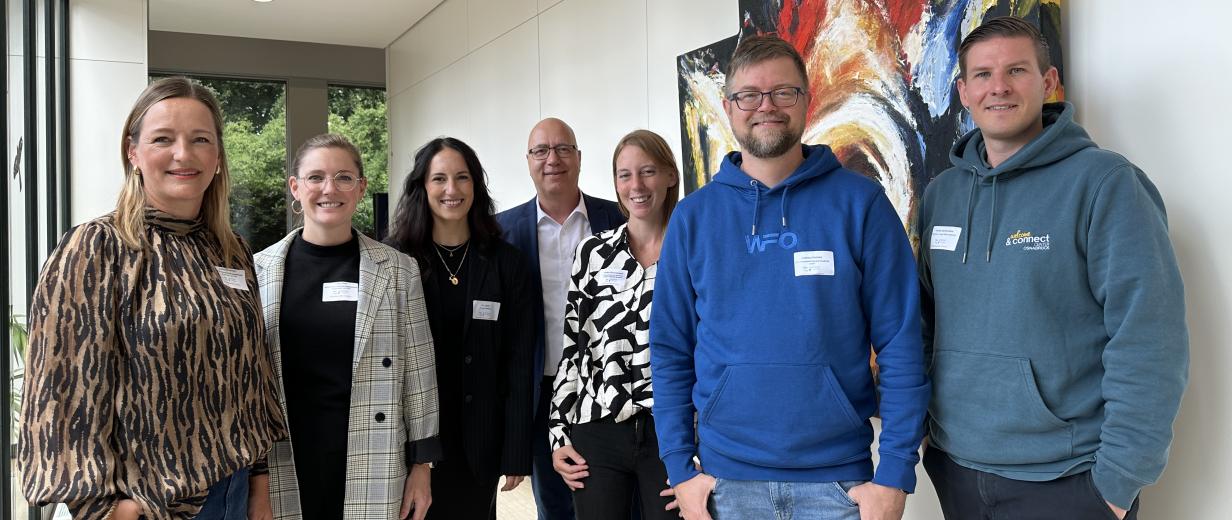 Fachkräftetag, Unternehmen, WIGOS Sieben Personen stehen in einem Foyer und schauen in die Kamera.