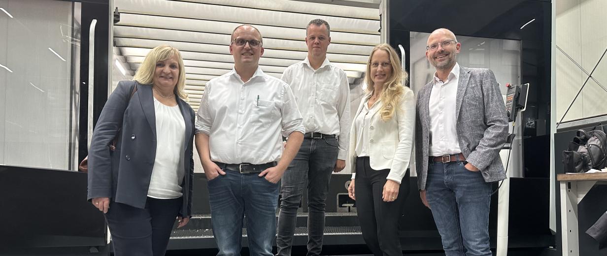 Riemann Werkzeugbau Landrätin Unternehmensbesuch Fünf Personen stehen in einer Werkhalle.
