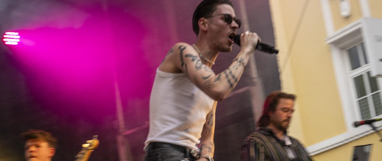 Plattsounds Frry Sänger und eine Band stehen auf einer Freilichtbühne