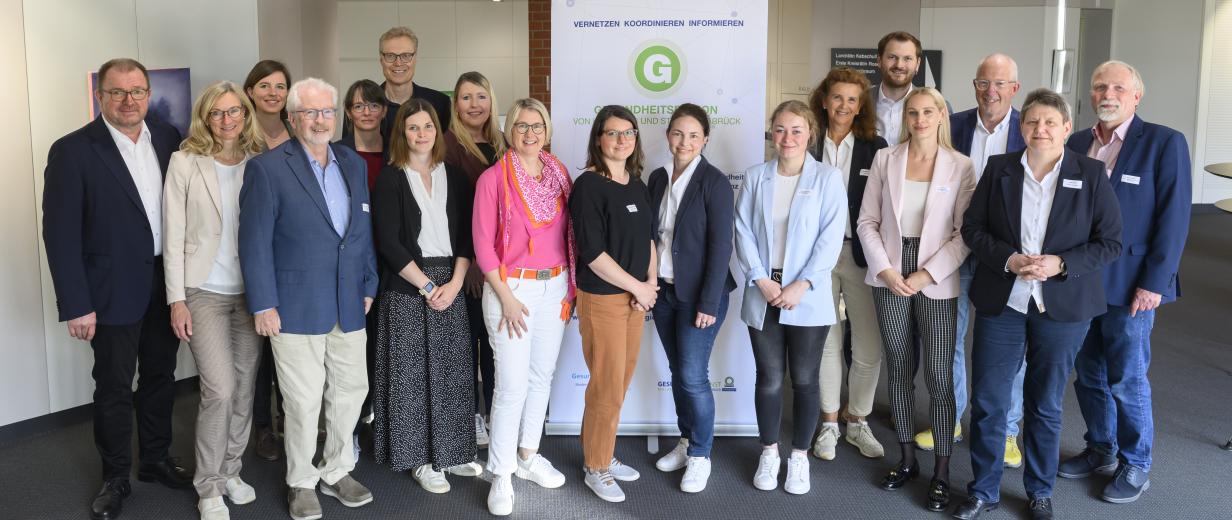 Gesundheitskonferenz 2025 Eine Personengruppe steht in einem Foyer.