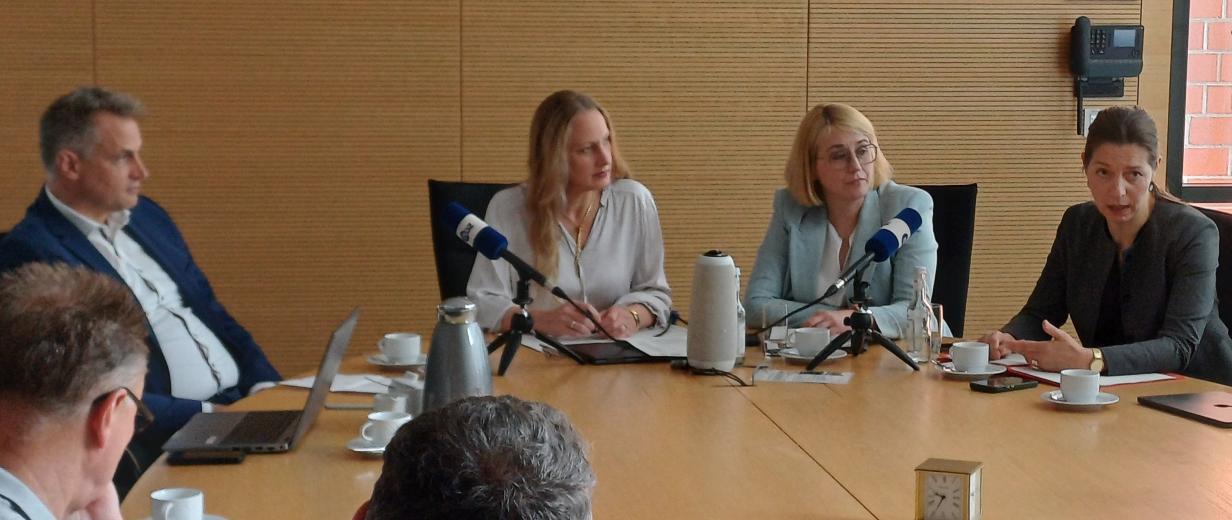 Gründung Medizinische Hochschule, Pressekonferenz Fünf Personen sitzen um einen Besprechungstisch herum.
