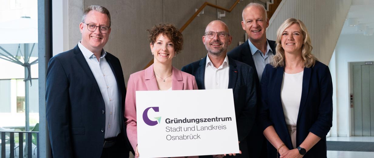 Gründung des Gründungszentrums Stadt und Landkreis Osnabrück Fünf Personen stehen im Treppenhaus eines Bürogebäudes.