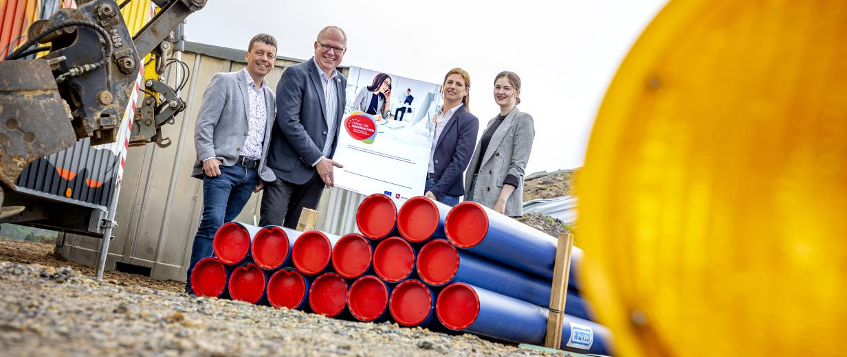 4 Personen stehen vor Baustelle