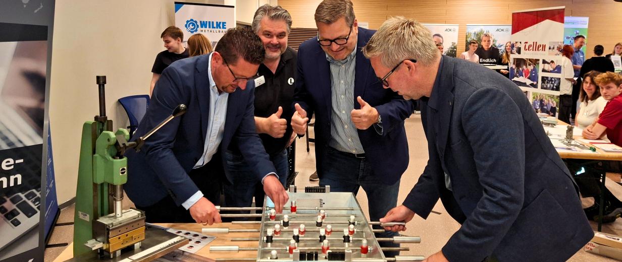 BOP MaßAbeit Vier Personen stehen an einem Kickertisch.