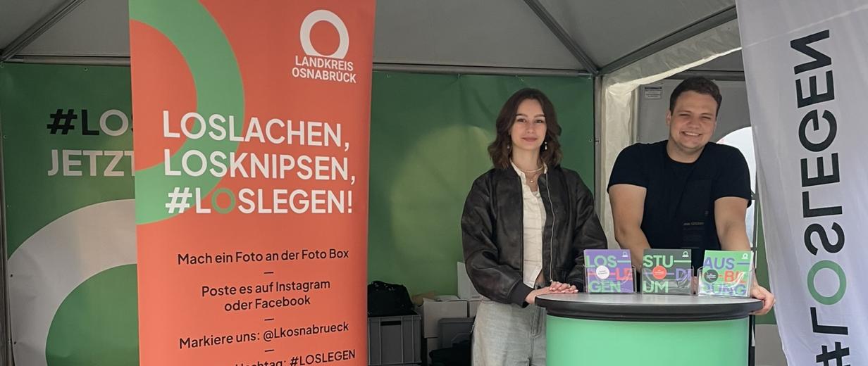 Zwei Personen stehen an einem Messestand.