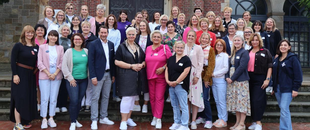 Personengruppe steht vor einer Kirche