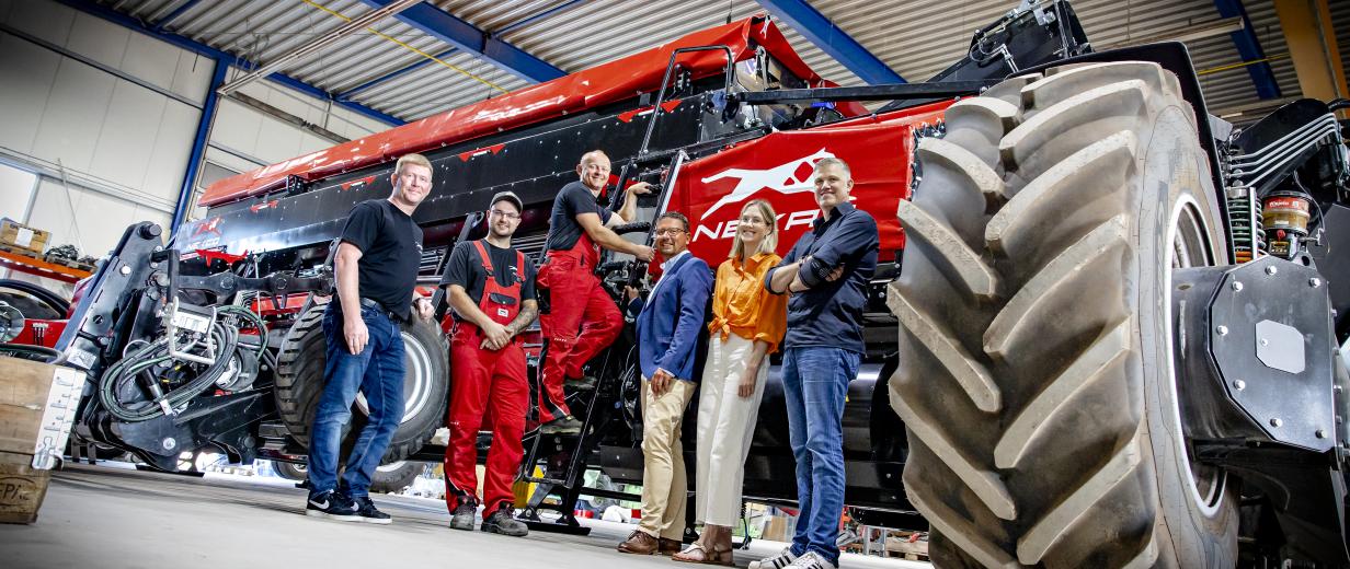 Ukrainer legt bei High-Tech-Landmaschinen von NEXAT Hand an Gruppe von Personen in Halle mit Landmaschinen