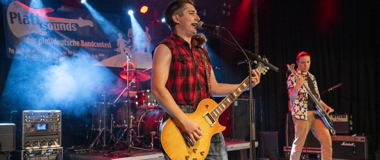 Drei Rockmusiker auf einer Bühne