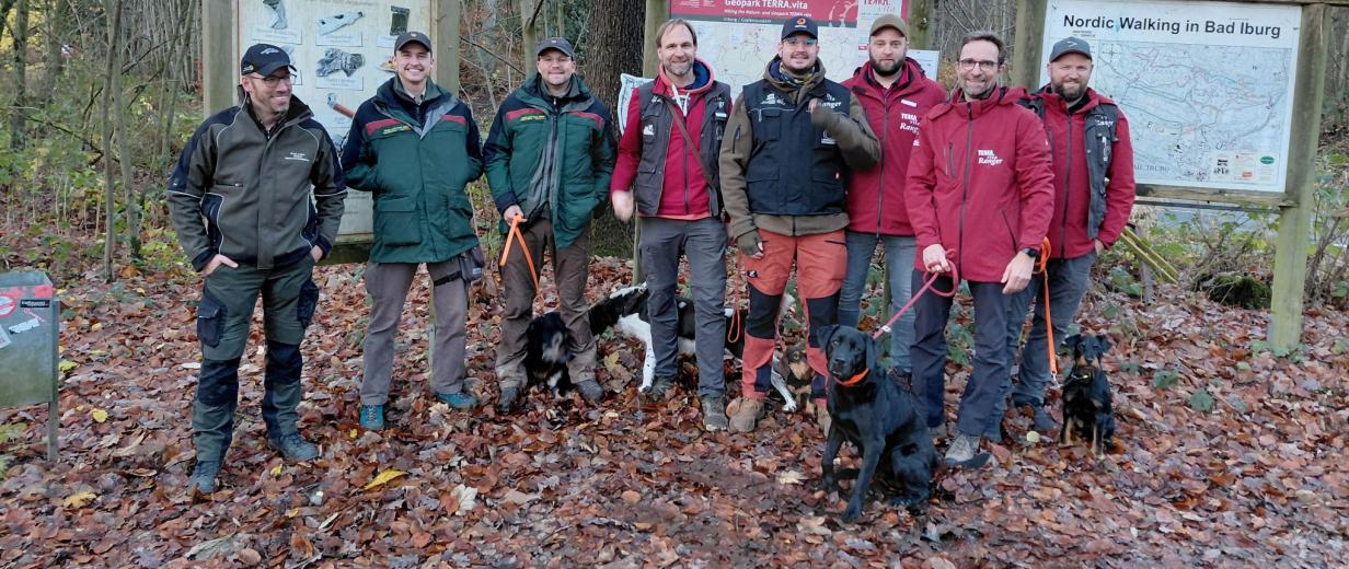 Personengruppe steht auf einer Waldlichtung