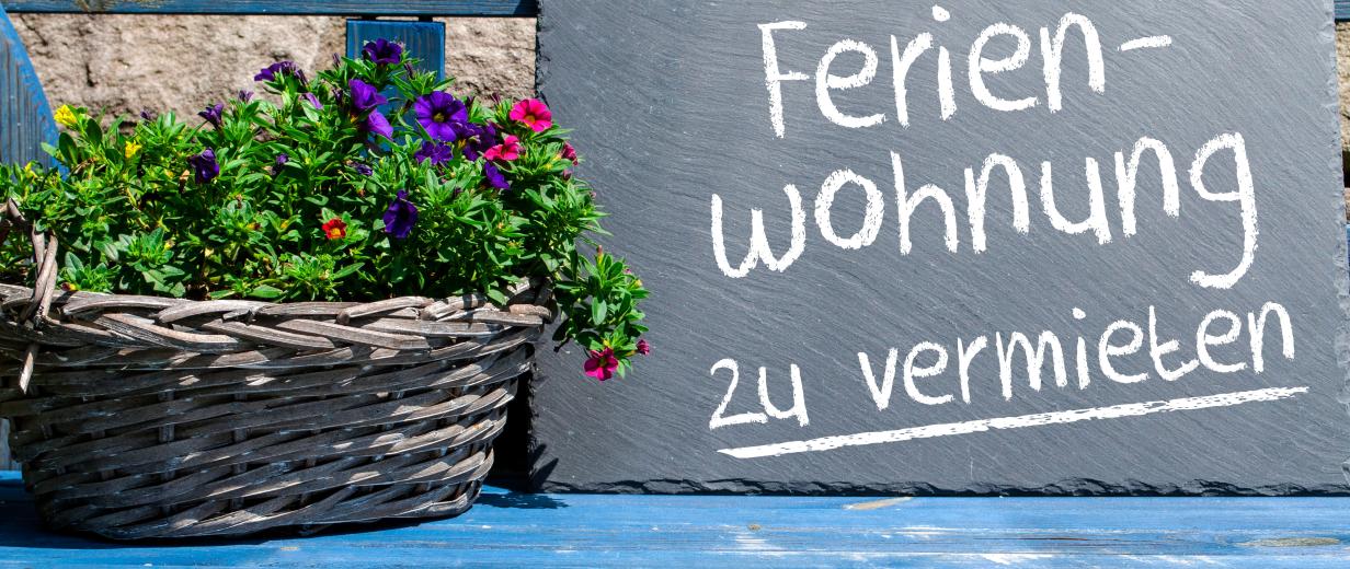 Schild steht auf einer Bank mit der Aufschrift Ferienwohnung zu vermieten.