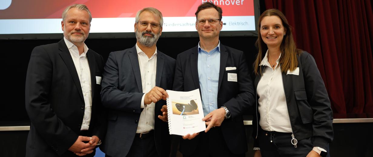 Vier Personen stehen auf einer Bühne.