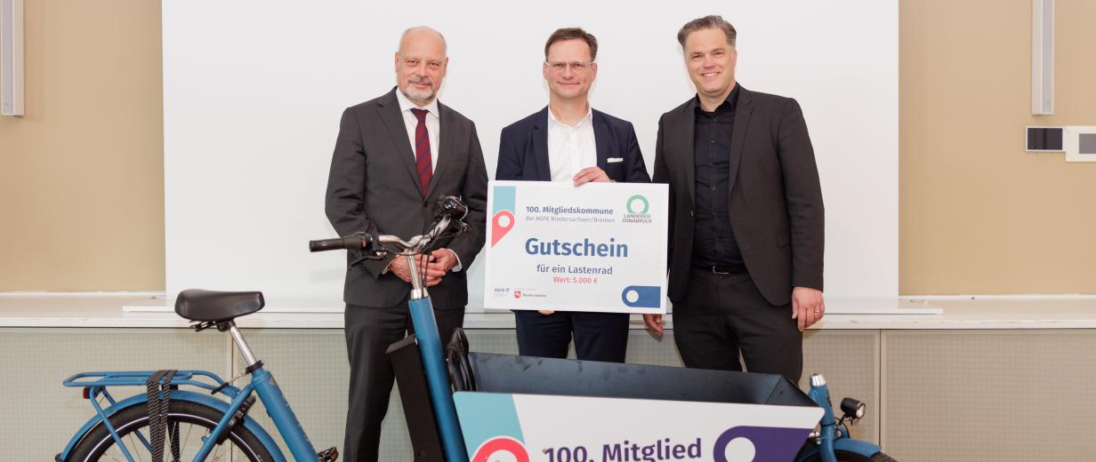 3 Personen vor Lastenrad