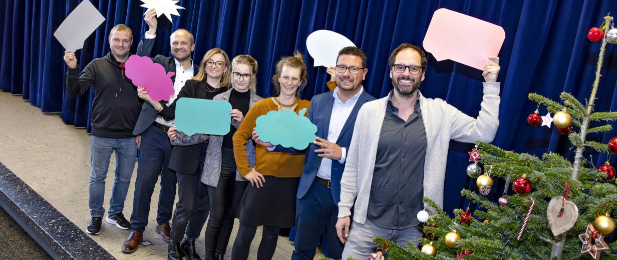 Eine Personengruppe steht auf einer Bühne