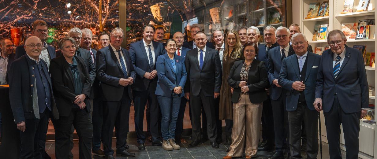 Eine Personengruppe steht in einem Foyer.