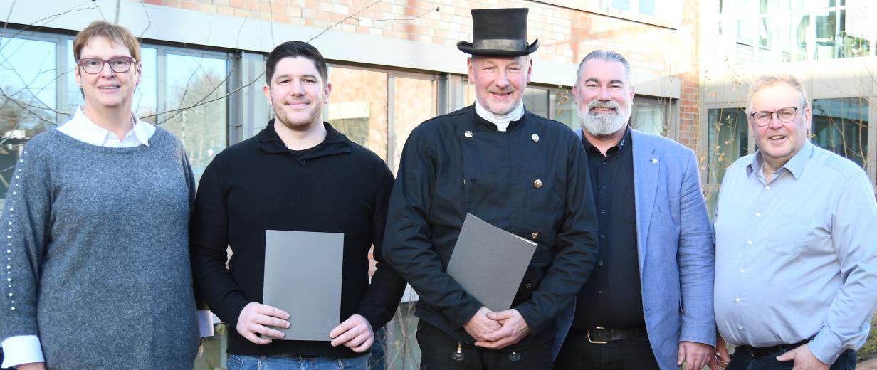 5 Personen vor Haus stehend